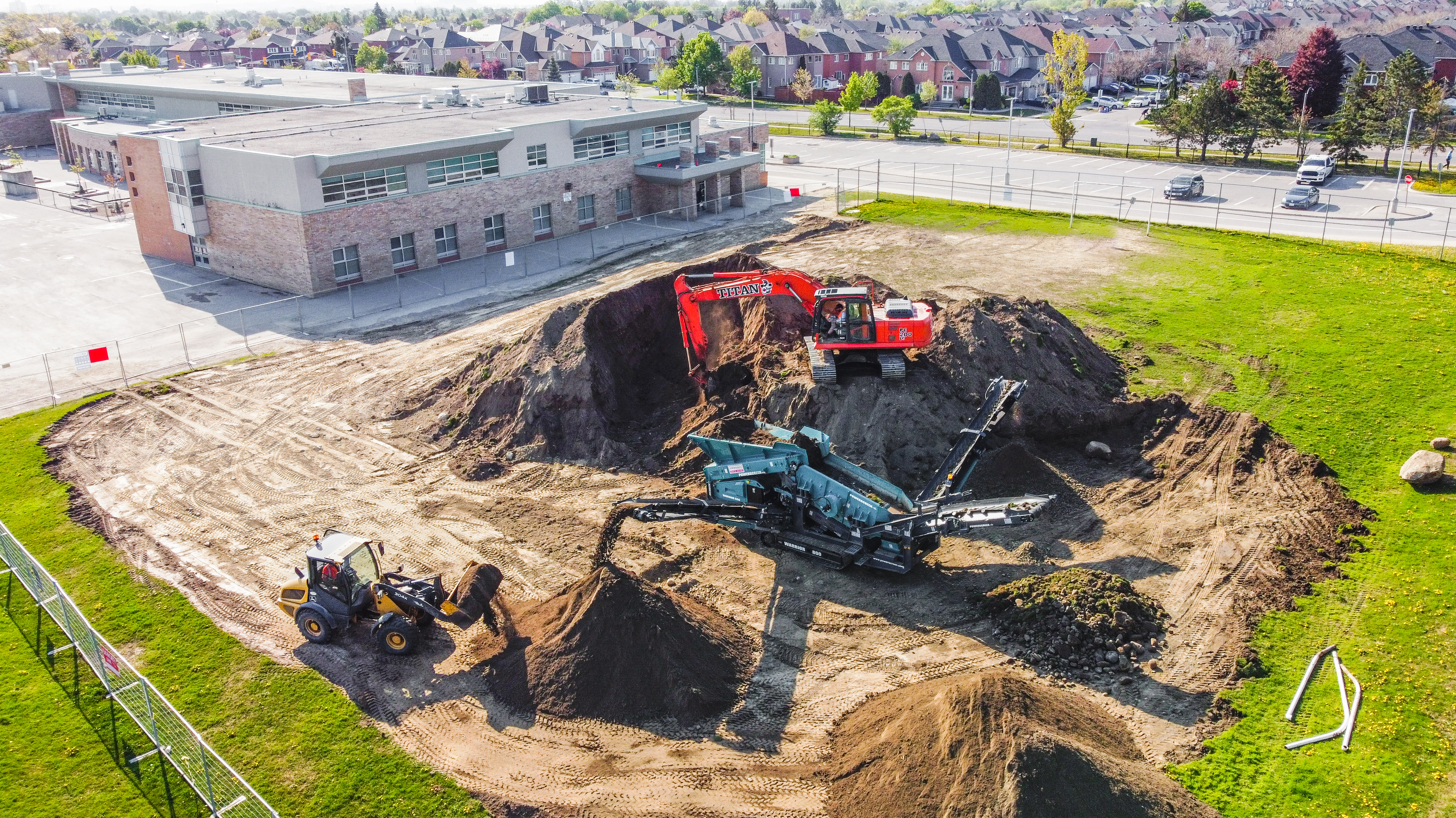 Construction vehicles on a school's field