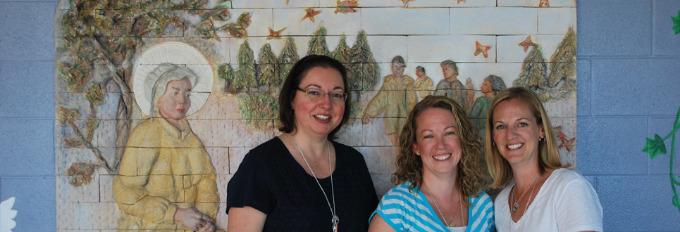 Three female adults standing in a hallway